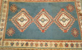 A decorative rug with  three medallions on a blue field within three borders 130cm wide,