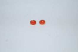 A pair of coral ear studs, the butterfly backs stamped '750', 1.