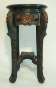 A carved and painted jardinière stand in oriental style, painted in colours on a black ground,