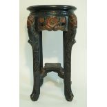 A carved and painted jardinière stand in oriental style, painted in colours on a black ground,