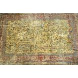 A Persian silk rug, woven with birds, animals, flowering trees and a temple on a yellow ground,