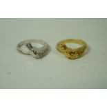 A pair of 18 carat gold horse head rings, one in yellow gold the other in white gold, finger size M,