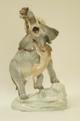 A late 19th century Amphora porcelain figure of an elephant attacked by lions,