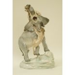 A late 19th century Amphora porcelain figure of an elephant attacked by lions,