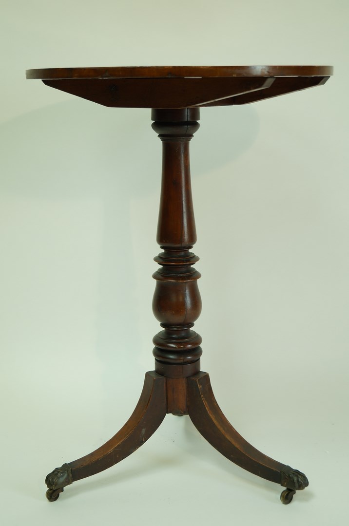 A tilt top occasional table, with yew top on turned mahogany pedestal and splayed legs,