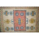 A decorative rug  with central rectangular medallion on an ivory field within two borders,