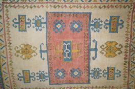 A decorative rug  with central rectangular medallion on an ivory field within two borders,