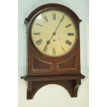 A mahogany cased wall clock, the round painted dial with arched case, above a double panelled front,