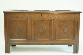 A 17th century oak coffer, with carved triple panel front, 70cm high, 124cm wide,