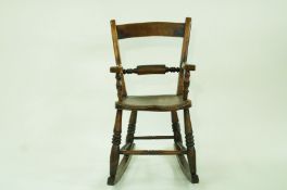 A 19th century child's rocking chair with arms,