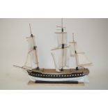 A 20th century model of a Man O War, with three masts, on rectangular plinth titled H.M.S.