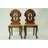 A pair of Victorian mahogany hall chairs with pierced carved backs and cabriole legs