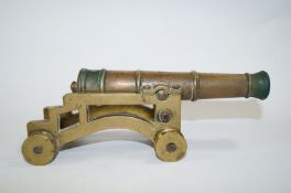A 19th century model brass canon on four wheeled carriage, moulded 1849,