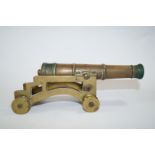 A 19th century model brass canon on four wheeled carriage, moulded 1849,