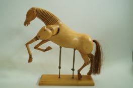 A carved wooden maquette of a horse, jointed with horse hair tail on an adjustable stand,