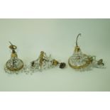 A set of three graduated ceiling lights each with cut glass drops, one 40cm high,
