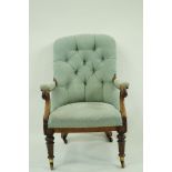 An early Victorian button back chair on turned and fluted legs on brass casters