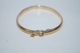 A 9ct gold hinged bangle, of hollow D section and half engraved, 0.5 cm wide, internal diameter 6.