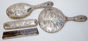 A silver four piece dressing table set, Birmingham 1971, decorated with cherubs heads,
