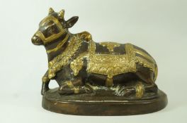 A 20th century bronze figure of a yak at rest, with polished ceremonial harness, 20.