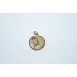 An Edwardian gilt metal commemorative picture pendant in gilt metal with a picture of Queen