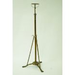 A  Victorian telescopic brass standard lamp on three paw feet,