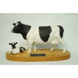 A Beswick connoisseur model of a Friesian cow and calf with matt glaze on wooden plinth with title