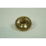 An early Victorian brooch, set with an oval cut foil backed stone, to a chased border mount, 2.