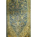 A decorative rug stylised animals and birds on a dark blue ground within multiple borders,