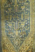 A decorative rug stylised animals and birds on a dark blue ground within multiple borders,