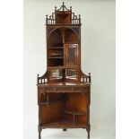 An early 20th century aesthetic movement rosewood corner cabinet, with peirced and carved panels,