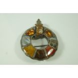 A Scottish hardstone brooch, in the form of a garter, also set with two foil backed stones,