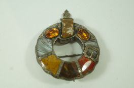 A Scottish hardstone brooch, in the form of a garter, also set with two foil backed stones,
