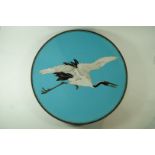 A  Japanese cloissone plate, decorated with crane in flight on a blue ground,