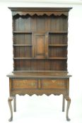 An oak dresser with raised back above two drawers on cabriole legs, 179cm high, 110cm wide,