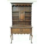 An oak dresser with raised back above two drawers on cabriole legs, 179cm high, 110cm wide,