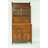 An Edwardian mahogany aesthetic movement side cabinet with two glazed doors above a horizontal