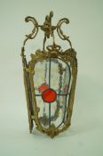 A hanging hall lantern with four stained glass panels,