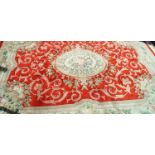 A Chinese carpet with central flower medallion on a bright red field within one wide border,