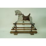 A Victorian carved wood and painted rocking horse on stand with leather saddle, 96cm high,