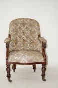 A Victorian tub shaped button back armchair with mahogany arms and turned legs