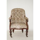 A Victorian tub shaped button back armchair with mahogany arms and turned legs