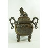 A 20th century bronze koro, with a dog of Fo finial, two handles and standing on four mask feet,