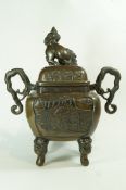 A 20th century bronze koro, with a dog of Fo finial, two handles and standing on four mask feet,