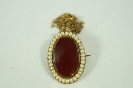 A cornelian and split pearl brooch/pendant,