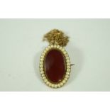 A cornelian and split pearl brooch/pendant,