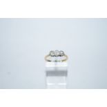 A three stone diamond ring, stamped '18ct&P', the graduated old cut stones illusion set,
