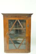 A 19th century mahogany hanging corner cupboard, with one glazed door, 105cm high, 77cm wide,