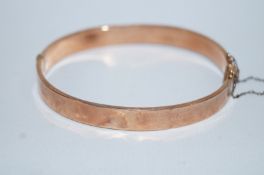A 9ct gold hinged bangle, with engine turned decoration, 8.