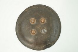 A round leather shield with three copper and one metal stud, 47.